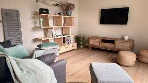 a living room with a flat screen tv on the wall at Ty Glaz - Maison Bord de mer avec jardin, proche plage in Roscoff
