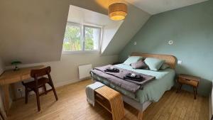 a bedroom with a bed and a table and a window at Ty Glaz - Maison Bord de mer avec jardin, proche plage in Roscoff