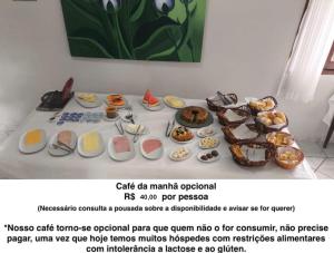 a table with a bunch of food on it at POUSADA NOSSA SENHORA in Penedo