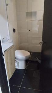 a bathroom with a white toilet and a sink at Apartamentos Acogedores Laureles in Medellín