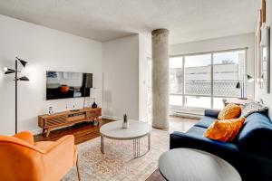 a living room with a blue couch and a table at Le Mille Neuf Apartments Modern Comfort in Downtown Montreal in Montréal