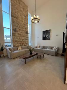 a living room with two couches and a table at אלמה בוטיק - וילה מהממת עם בריכה פרטית in Shlomi