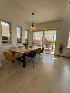 a dining room with a wooden table and chairs at אלמה בוטיק - וילה מהממת עם בריכה פרטית in Shlomi