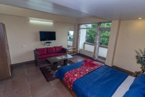 大吉岭Sierra Inn的一间带床、沙发和电视的卧室