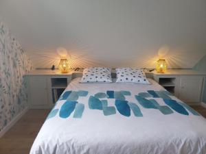 Pont-du-NavoyにあるL'Aintemporel - Gîte calme 4 personnesの白いベッドと青い枕のある寝室