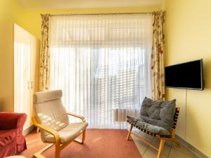 a living room with a chair and a window at Unvergessliches Apartment am See in Granzow