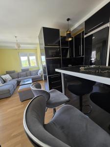 a kitchen and living room with chairs and a table at Apartmani Pezerović in Soko Banja +56 photos