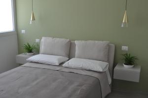 a bedroom with a bed with two pillows and two plants at Giovhome in Giovinazzo