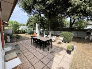 a patio with a table and chairs and a umbrella at Résidence 100-soulac Sur Mer - 100 - Charmante maison dans le quartier des Arros MAE-1951 in Soulac-sur-Mer