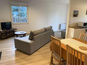 滨海苏拉克Résidence La Grande Combe - 149 - Élégante maison rénovée avec goût et son parc verdoyant MAE-0101的客厅里有一张沙发和一张桌子。