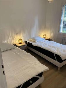 滨海苏拉克Résidence La Grande Combe - 149 - Élégante maison rénovée avec goût et son parc verdoyant MAE-0101的配有两张床铺的房间,配有两盏灯