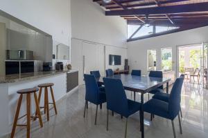 a kitchen and dining room with a table and chairs at Casa com Piscina climatizada , Jacuzzi 4 Quartos. in Bertioga