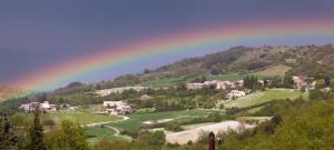 a rainbow in the sky over a valley with houses at Gîte du Four à Chaux in Quillan