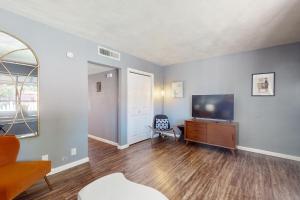 a living room with a flat screen tv and a chair at Glendale Groovin' in Glendale