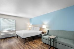 a hotel room with a bed and a couch at WoodSpring Suites Savannah West - Ellabell Metaplant in Ellabell +55 photos