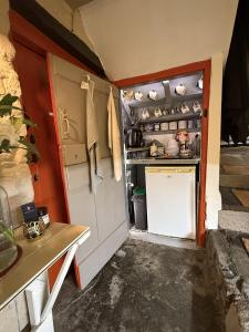 a small kitchen with a stove and a refrigerator at Charming two-bedroom apartment, One Drake Road, Tavistock in Tavistock +6 photos