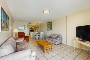 a living room with a couch and a tv at Ocean House I 1702 in Gulf Shores