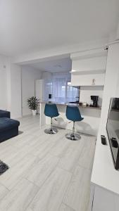 un soggiorno con due sedie e una cucina di Apartament Alb&Negru a Sebeş