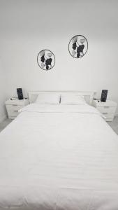 una camera con un letto bianco con due immagini sul muro di Apartament Alb&Negru a Sebeş