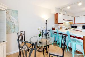 a kitchen with a glass table and blue chairs at Emerald Skye 42 in Orange Beach