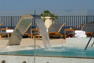 uma fonte de água num pátio com mesas e cadeiras em Hotel Villa Carolina em Ischia