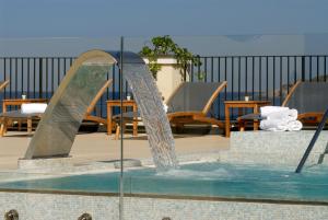 una fuente de agua en un patio con mesas y sillas en Hotel Villa Carolina, en Isquia