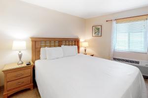a bedroom with a large white bed and a window at Emerald Skye 42 in Orange Beach +15 photos
