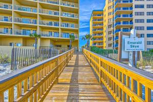 a wooden boardwalk leading to a building with a sign at Emerald Skye 42 in Orange Beach