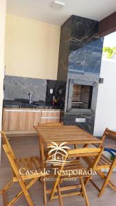 a kitchen with a wooden table and two chairs at Sua casa pertinho da praia in Camocim