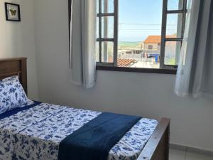 a bedroom with a bed and a window with a view at Hostel onda azul in Serra
