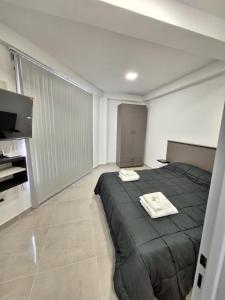 Un dormitorio con una cama con dos toallas encima. en Edificio Eclipse, en Ushuaia