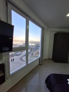 Un dormitorio con una gran ventana con vistas. en Edificio Eclipse, en Ushuaia
