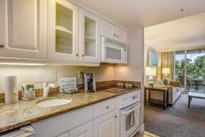 eine Küchenzeile mit Spüle und ein Wohnzimmer in der Unterkunft Marco Beach Ocean Resort Condominiums #605 in Marco Island