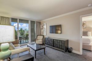 ein Wohnzimmer mit einer Couch und einem Bett und einem Fernseher in der Unterkunft Marco Beach Ocean Resort Condominiums #605 in Marco Island