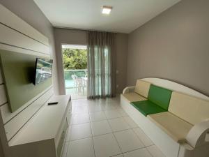 Una sala de estar con un sofá y una ventana. en cód 33 · Apartamento a 80 metros da praia, en Governador Celso Ramos