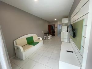Una sala de estar con un sofá blanco y un televisor. en cód 33 · Apartamento a 80 metros da praia, en Governador Celso Ramos