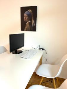 un escritorio con una computadora y una foto de una mujer en Japandi-Style in Dortmund mit Stellplatz, Balkon, en Dortmund