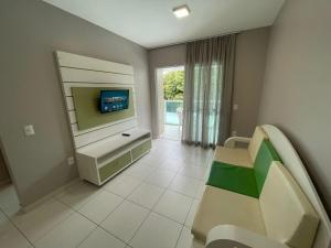 a living room with a tv and a couch at Cód 34 · Apartamento a 80 metros do mar in Governador Celso Ramos