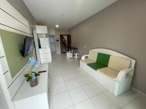 a living room with a couch and a refrigerator at cód 36 · Apartamento a 80 metros do mar com sacada in João Neiva