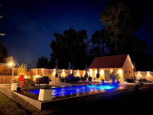 a backyard at night with a swimming pool at Sparhof in Dranouter