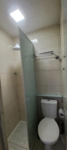 a bathroom with a white toilet and a shower at Loft Portal Beach 03 in Recife