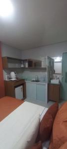 a bedroom with a large bed and a kitchen at Loft Portal Beach 03 in Recife