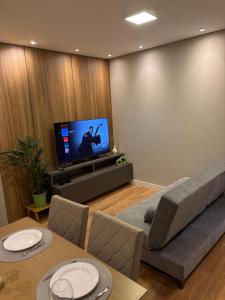 a living room with a couch and a tv at Apto Todo Climatizado 2 Quartos in Presidente Prudente