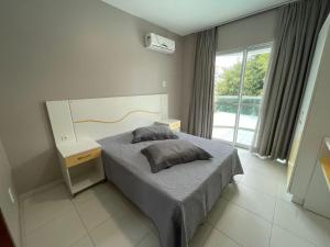 Un dormitorio con una cama y una ventana grande. en cód 39 · Apartamento com vista mar, en Governador Celso Ramos