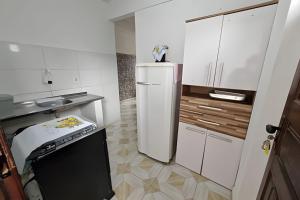 une petite cuisine avec un réfrigérateur et un évier dans l'établissement Hospedaria Quitandinha, à Petrópolis
