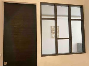 a black door and a window in a room at Appartement au bord de l'eau in Le Grau-du-Roi