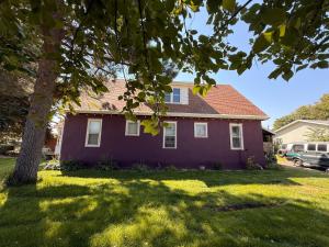 a purple house with a tree in the yard at 1912 Nostalgic TrainCrew Boarding House in Potter