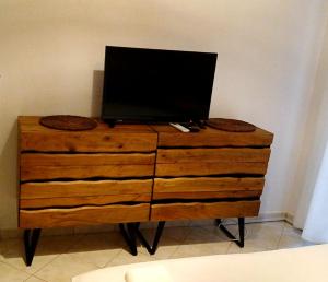 a wooden dresser with a television on top of it at Pefko Couple's Cave in Pefkohori
