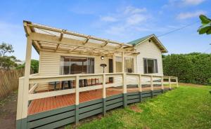 a house with a deck with a pergola at Ocean Road Retreat in Peterborough