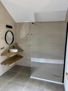 ein Badezimmer mit Dusche, Waschbecken und Spiegel in der Unterkunft Idyllic cottage with wellness facilities in Alveringem